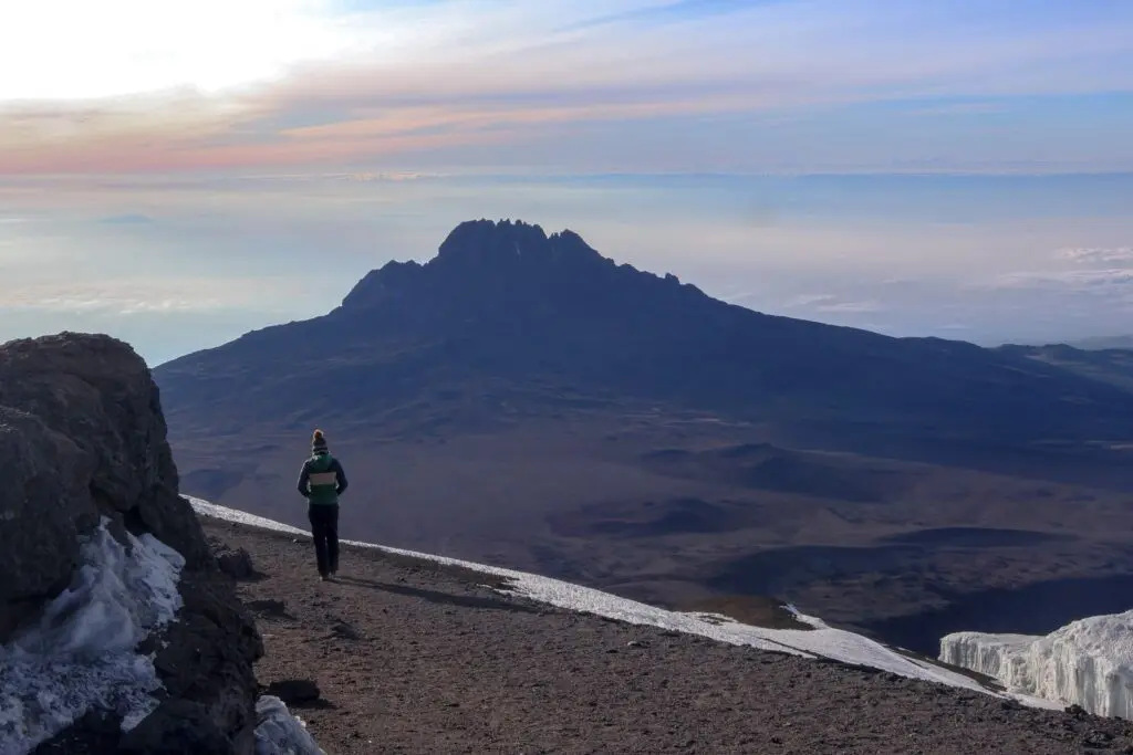hiker on Kilimanjaro trail with mountain view at sunrise